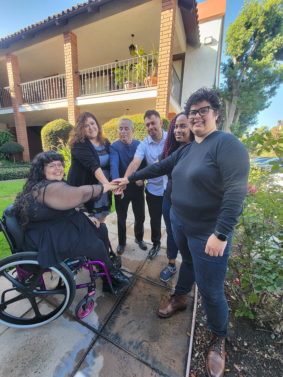 Michelle, Director of Community Support Services calling 'all-hands' with Leads: L-R Nelly Gomez, Marisol Johnson, Paul Brennan, Ivan Cortez and Pamela Torress standing outside smiling