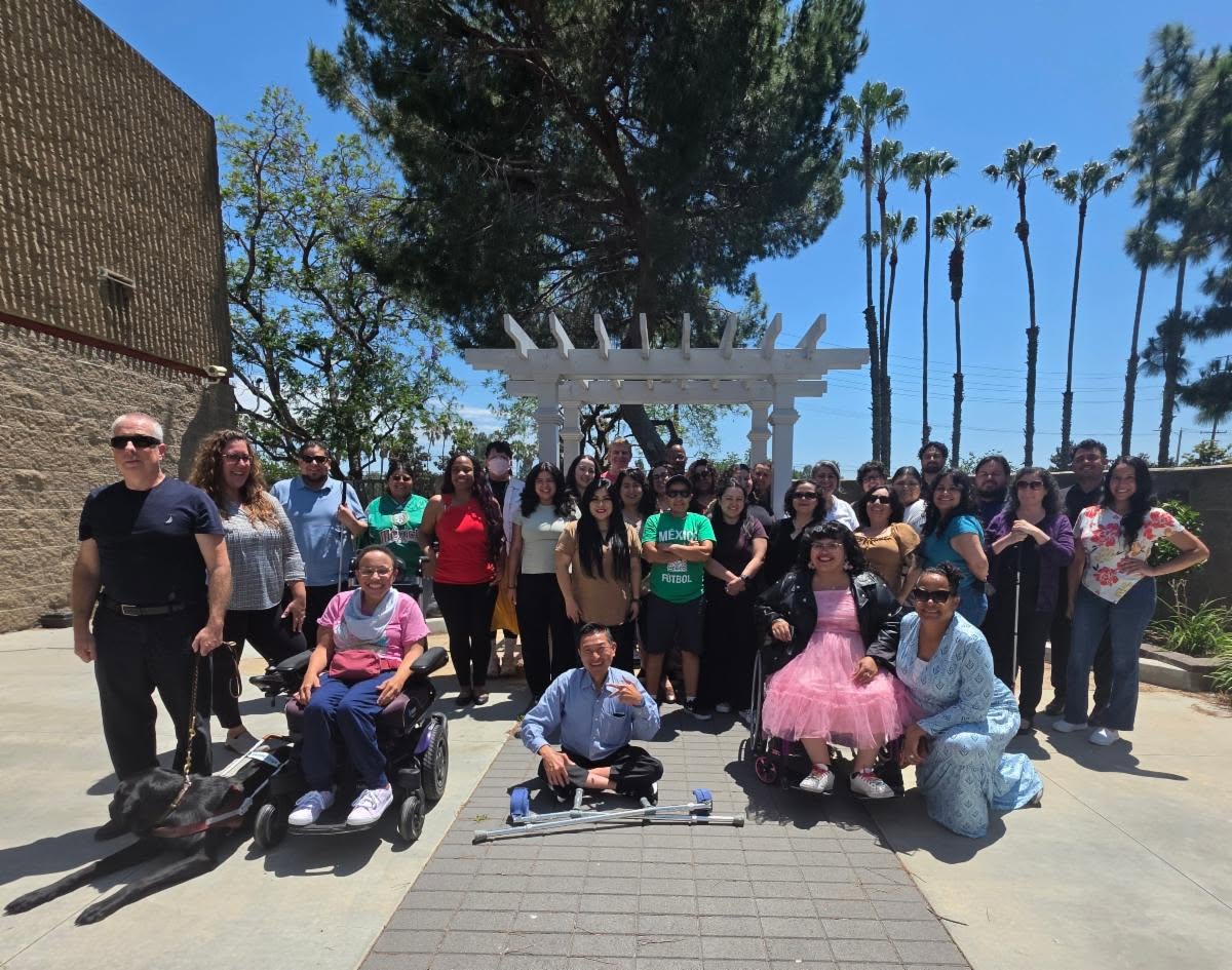 Team DMC 2026 gathered outside in group photo outside on sunny day with green trees and blue sky in the background