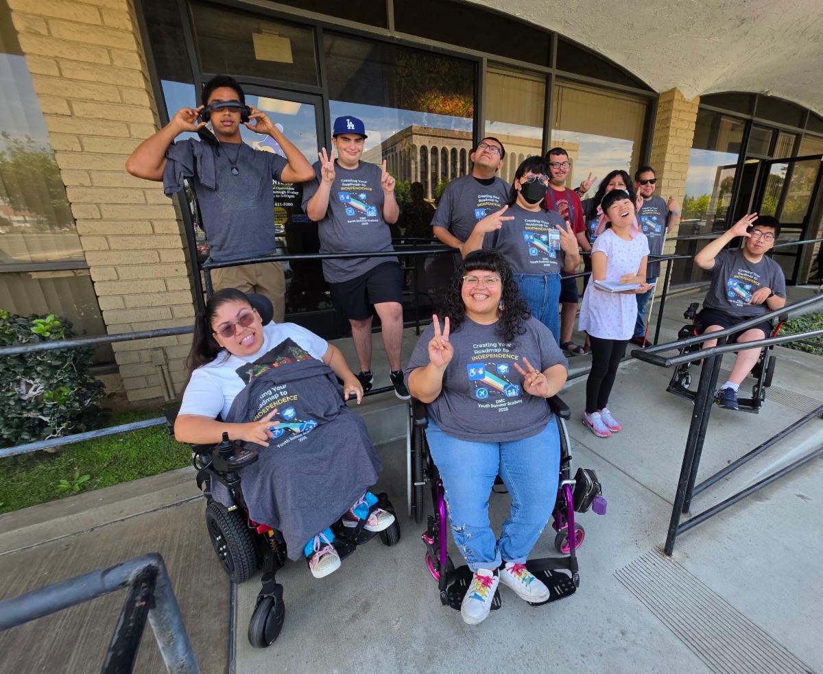 DMC Summer Youth Academy participants with Team DMC Youth Connect outside of DMC on ramp smiling, wearing Summer Youth Academy shirts, having fun connecting
