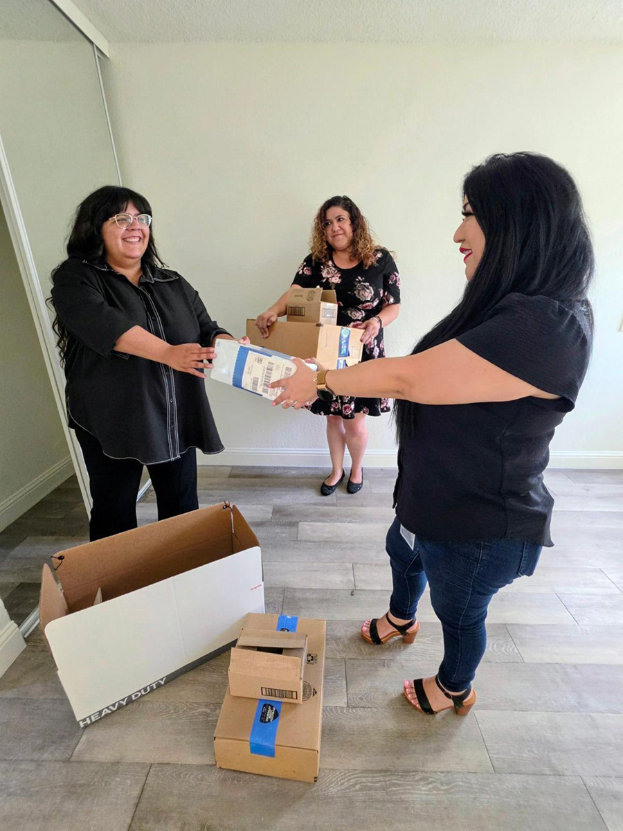 Housing team unpacking home goods inside apartment