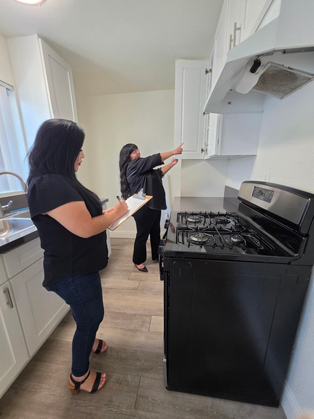 Monica and Paola inspecting apartment kitchen