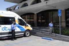 OCTA-Photo-Shoot-3-DMC-PAS-Recruitment-Specialist-using-ramp-to-meet-OC-ACCESS-in-parking-lot-attendant-is-motioning-they-are-there-to-assist
