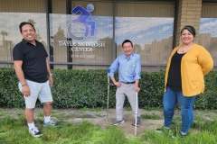 Photo-11-Pictured-older-adult-consumer-with-two-DMC-team-members-standing-in-front-of-DMC-building