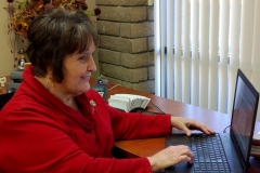 DMC Director Margeson at her desk using laptop