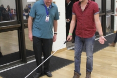 DMC Staff helping Chuy walk with cane while blind folded during sensativity excercise