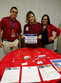 Community Services 3 staff doing an outreach standing at MMP resource table.