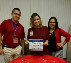 DMC Community Services 3 staff doing an outreach standing at MMP resource table.