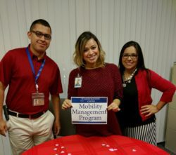 DMC Community Services 3 staff doing an outreach standing at MMP resource table.