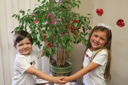 Donate. Picture of smiling boy and girl holding hands.