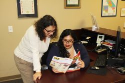 Information and Referral Coordinator reviewing resource book with consumer