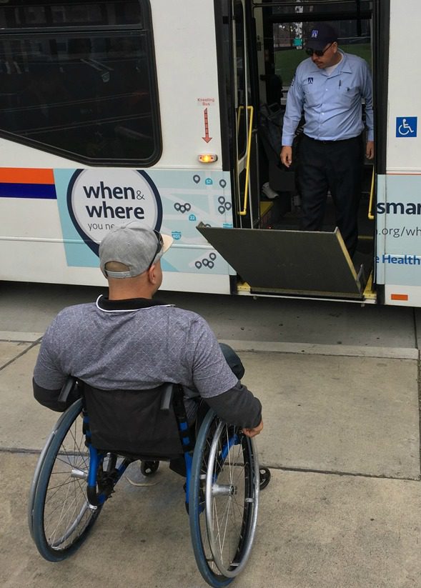 MMP Picture of OCTA bus driver lowering ramp for a man in wheelchair.