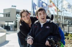 PAS Personal Assistance Services Caregiver with young adult that is in a power chair.