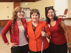 Three women in red blazers and dresses.
