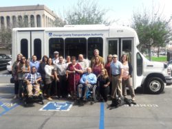 Group posing by Orange County bus.