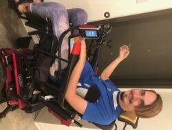Man in wheelchair smiling, holding a toy.