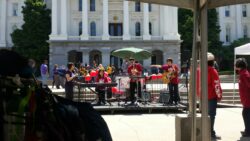 Band playing music in front of government building.