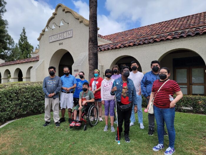 A group of youth posing in front of the Anaheim Accessibility Center.