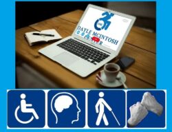 Photo of laptop on table. Dayle McIntosh Logo is on the computer screen; To the left of the laptop there is a notebook with a pen. To the right of the laptop a cup of coffee on a saucer with a spoon. Above the coffee is a cell phone.. Underneath this photo are disability symbols – Left to Right pictured are physical disability indicated by the universal wheelchair symbol; a mental health symbol with a human head and brain; a blind/low-vision symbol, person with a walking stick and support/advocate sign to represent deaf services. These symbols are white on a dark blue background. The image has a light blue border.
