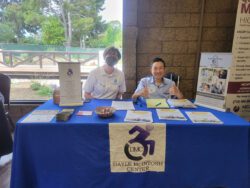 Team DMC smiling table-side, representing in the community at Resource Fair.