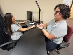 Two women talking at a desk.