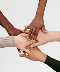 Pictured: Five hands stacked on each other representing teamwork and community. 