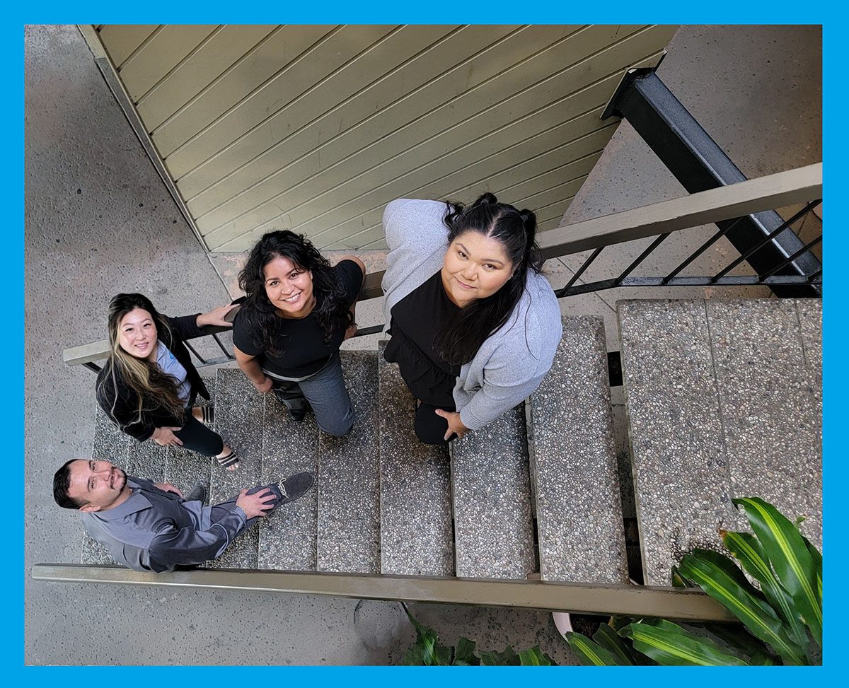 Pictured, Team DMC in open stairwell, looking upward above.