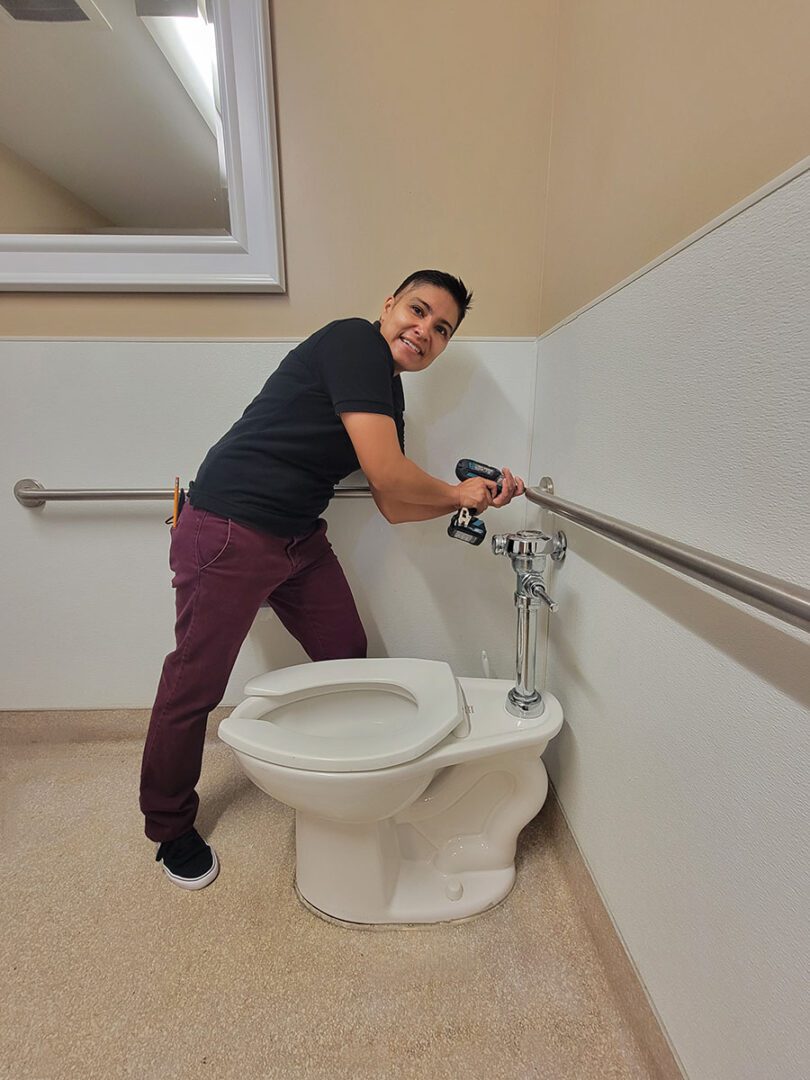 Ana installing grab bars around toilet for accessibility 