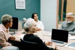 Pictured, Older adults learning about Assistive Technology Collaborative seated at table in front of computers.