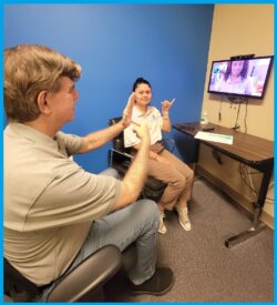 Pictured above Deaf Services Team Jet and Doryna signing inside DMC offices to Pamela on video screen to demonstrate social/soft skills plans for consumers.