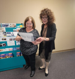 Pictured: Annette and Amy friends of DMC standing by information kiosk at the front office excited to learn about Volunteer opportunities at DMC to share with friends.
