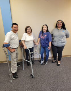 Kevin, Consumer, Caregiver, Judith inside DMC in front of beige wall with blue trim.