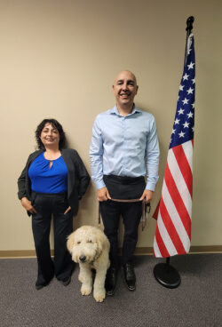 VIP Program Advisors Marysol Cuadrado and Eric Rodriguez standing by U.S. flag with “ Honey”