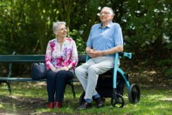 Two older adults in the park talking.