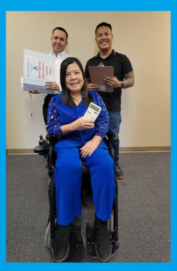 DMC Admin Team together smiling inside DMC. Miguel is holding Employee Procedures Handbook; Michael is holding a clipboard to track the team and Christine is holding a calculator to track financials.