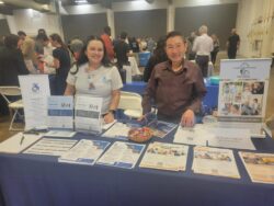DMC Volunteer Coordinator, Raquel and DMC PAS Recruitment Specialist, Kevin at Job Fair with DMC flyers at event table top booth