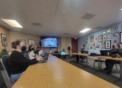 Southern California Systems Change Advocates Meeting inside DMC Office Confernce room – both in-person and on big screen virtual in background.